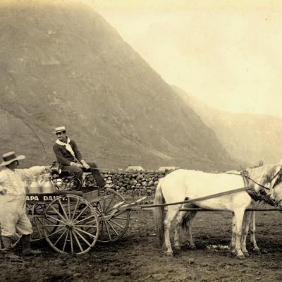 Emil Van Lil in gesprek met Albert Galaspo, koetsier van de melkkar. In de achtergrond, de ‘pali’, natuurlijke grens met de melaatsenkolonie op Molokaï. (Foto: Leuven, Damiaan Documentatie & Informatiecentrum)